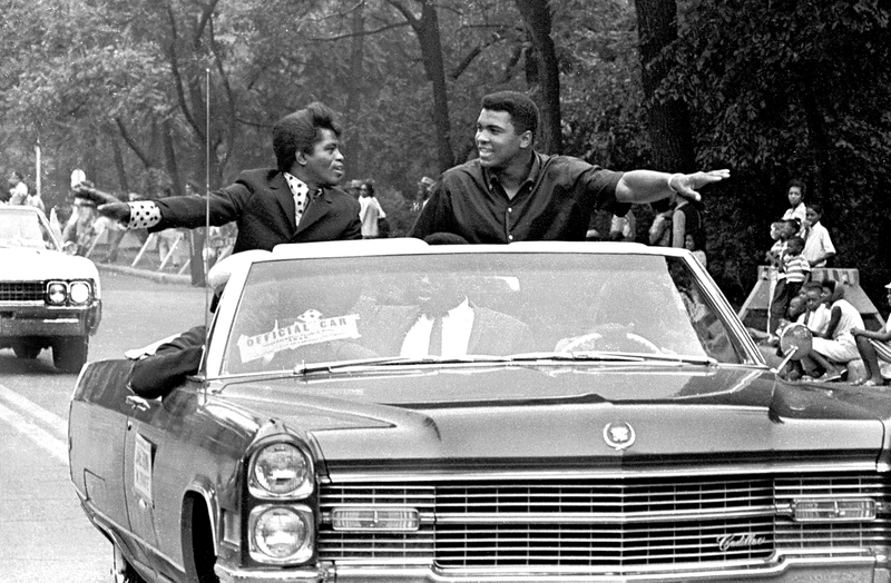 American singer James Brown (1933 - 2006) and boxing champ Muhammad Ali (then known as Cassius Clay), smile and greet parade goers while participating in the annual Bud Billiken parade, Chicago, Illinois, August 1966. Robert Abbott Sengstacke/Getty Images